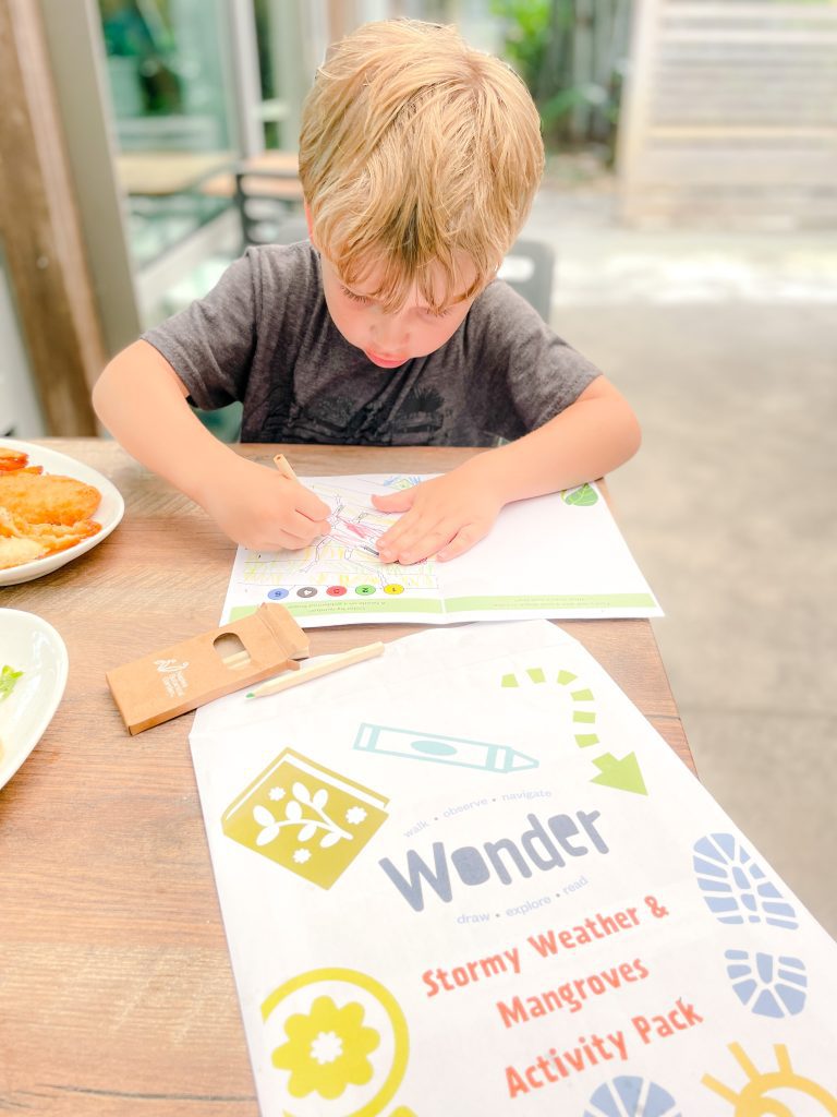 A child working on worksheets from the Naples Botanical Garden.
